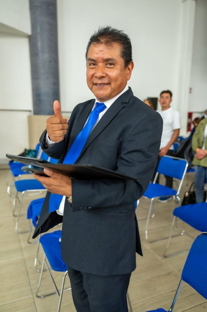 A man in a suit giving the thumbs up